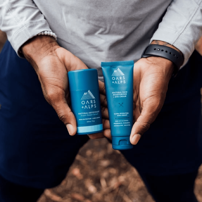 man holding face cream and deodorant