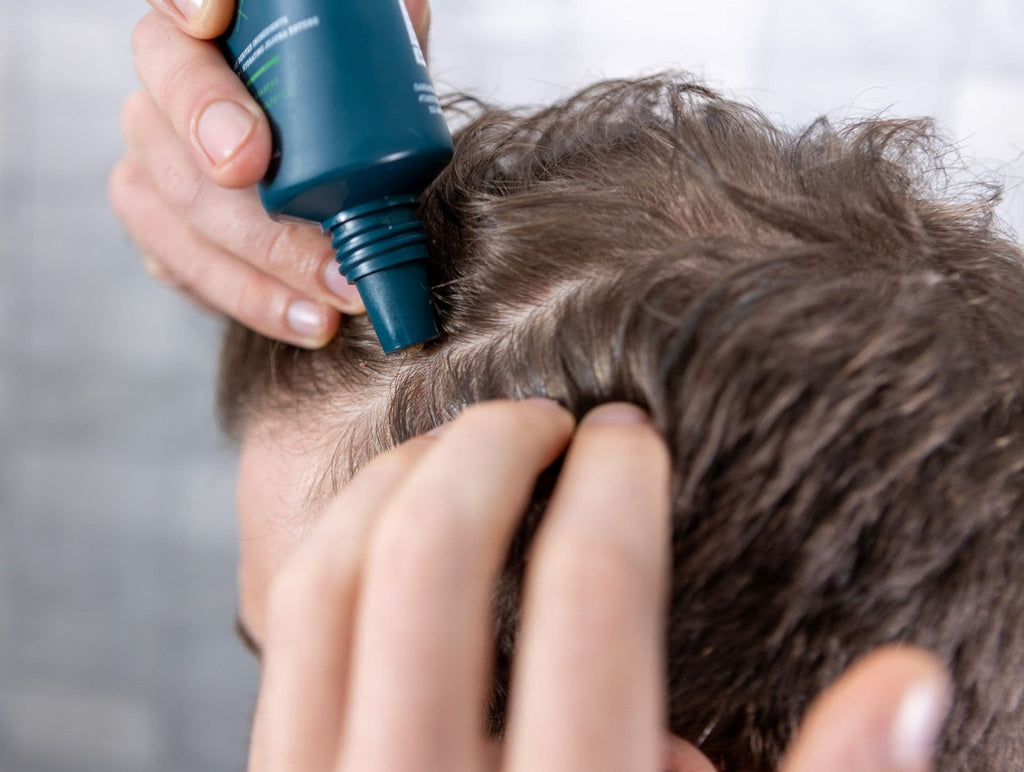 Man applying scalp scrub to treat dandruff