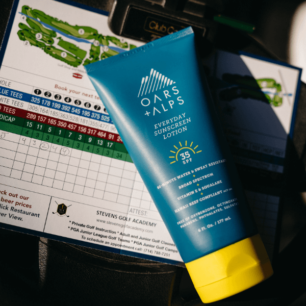oars and alps sunscreen on top of a golfing score card