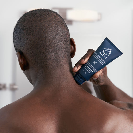 A male athlete applying Muscle Recovery Balm after a workout.
